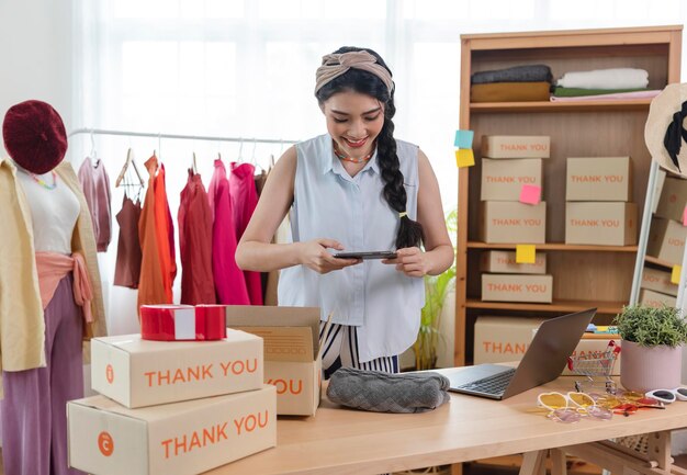 Uma jovem asiática vende um empresário de roupas que trabalha em casa, um pequeno empresário PME