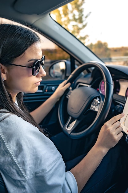 Foto grátis uma jovem atraente a conduzir um carro usa um navegador