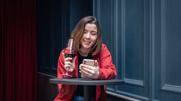 Uma jovem com um copo de vinho no terraço de um restaurante