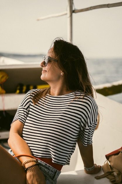 Uma jovem de óculos de sol viaja em um barco no oceano.
