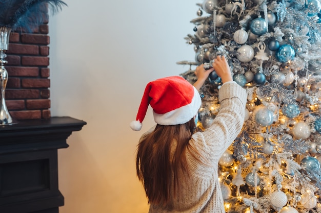 Uma jovem decorando a árvore de natal
