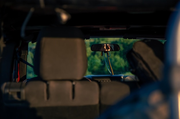 Uma jovem dirigindo um suv vermelho no campo enfrenta reflexão