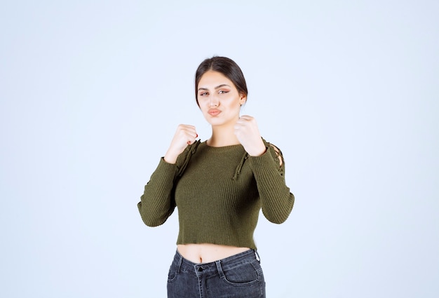 Uma jovem e adorável modelo em verde mostrando como dar um soco