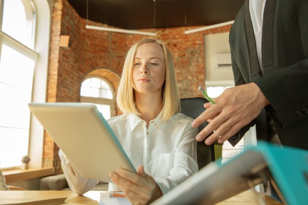 Uma jovem empresária se movendo no escritório, conseguindo um novo local de trabalho. Jovem trabalhadora de escritório encontra seu colega ou colega de trabalho após a promoção, recebendo ajuda. Negócios, estilo de vida, novo conceito de vida.