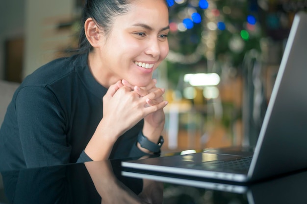 Uma jovem feliz é surpreendente ao usar o laptop do computador no café