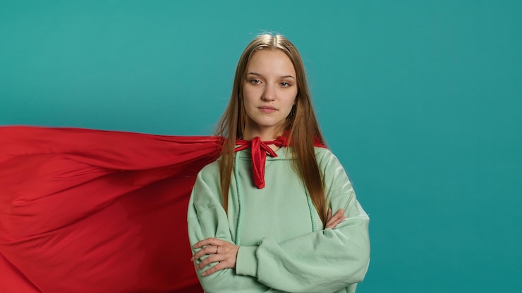 Foto grátis uma jovem feliz interpretando um super-herói voando com uma capa flutuando no vento.