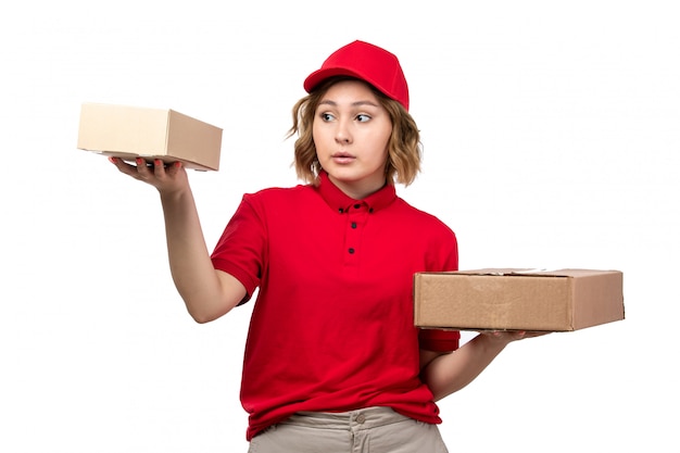 Uma jovem mensageira com boné vermelho de camisa vermelha segurando pacotes de entrega