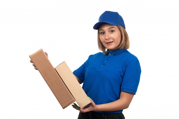 Foto grátis uma jovem mensageira de uniforme azul segurando pacotes de entrega de comida