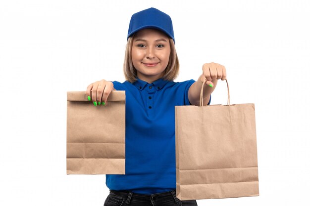 Uma jovem mensageira de uniforme azul segurando pacotes de entrega de comida