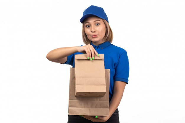 Uma jovem mensageira de uniforme azul segurando pacotes de entrega de comida