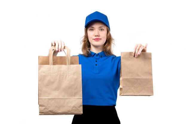 Uma jovem mensageira de uniforme segurando pacotes de entrega sorrindo