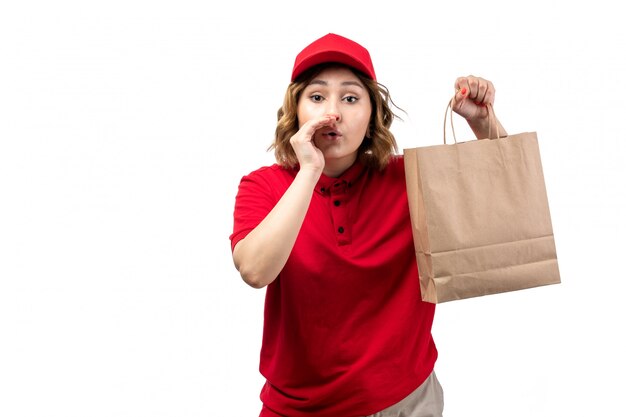 Uma jovem mensageira de uniforme segurando um pacote de entrega de comida e sussurrando