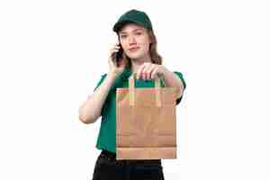 Foto grátis uma jovem mensageira de uniforme verde, sorrindo, segurando o pacote e falando ao telefone.