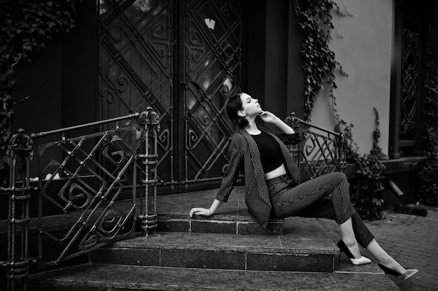 Foto grátis uma jovem modelo bonita e elegante de pernas altas com roupa formal posada nas escadas