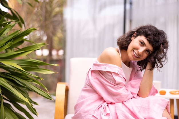 Uma jovem muito caucasiana com cabelo escuro em roupas casuais olha para a câmera sentada no quintal Conceito de estilo de vida de humor
