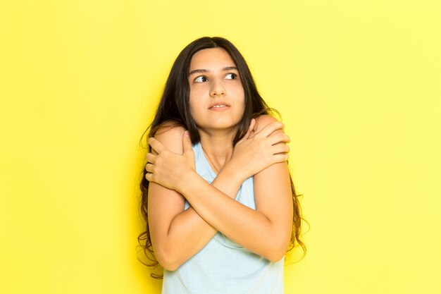 Uma jovem mulher de camisa azul, de frente para o frio