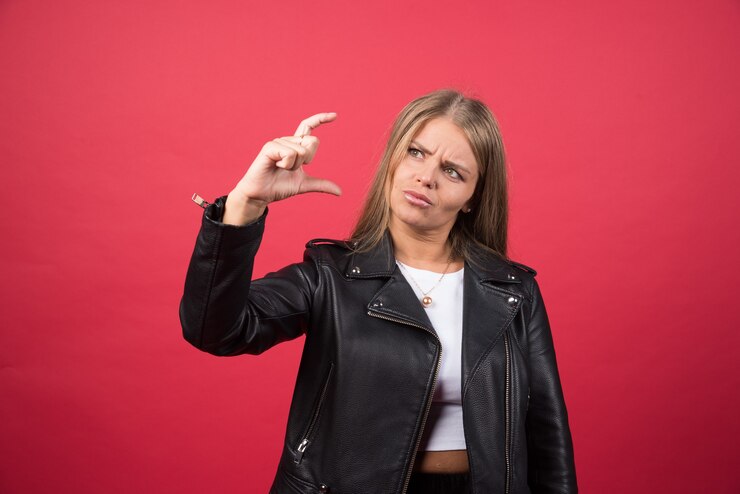 Foto grátis uma jovem mulher mostrando algo pequeno em tamanho com as mãos