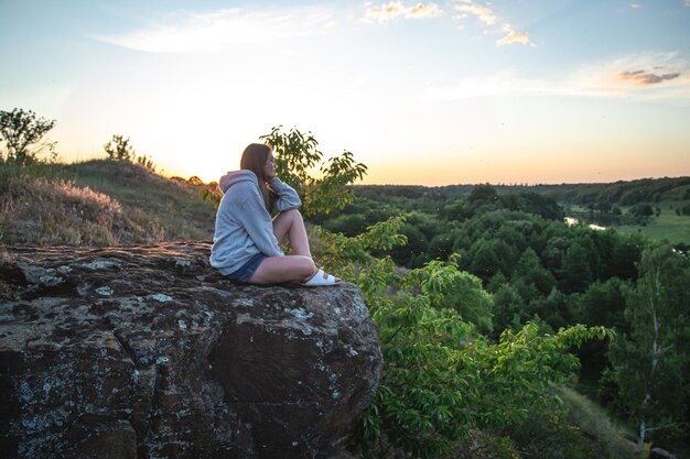 Uma jovem no fundo de uma paisagem florestal em uma área montanhosa