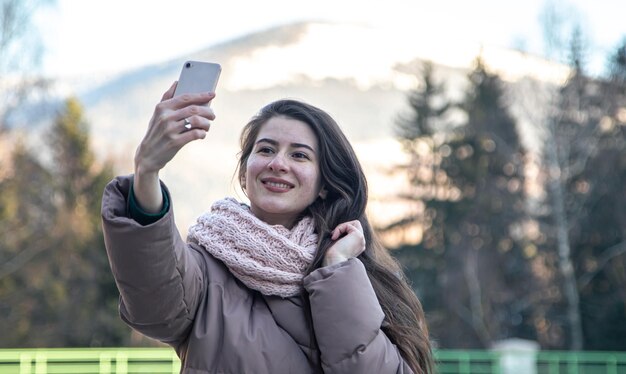 Uma jovem tira uma selfie em uma caminhada nas montanhas