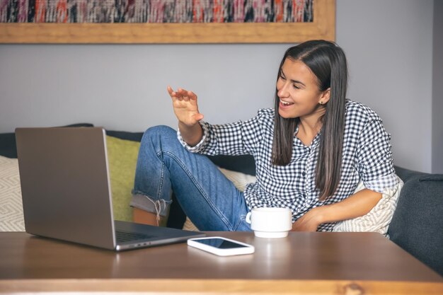 Uma jovem trabalhando em um laptop em casa