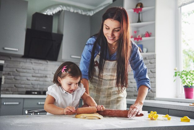 Uma linda filha com a mãe dela cozinhando na cozinha