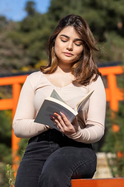 Uma linda garota lendo livro no parque Foto de alta qualidade