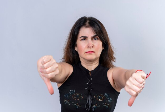 Uma linda mulher de blusa preta com os polegares tristes para baixo