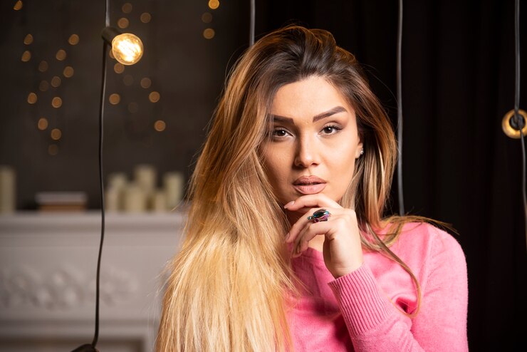 Foto grátis uma linda mulher de suéter posando perto de lâmpadas. foto de alta qualidade