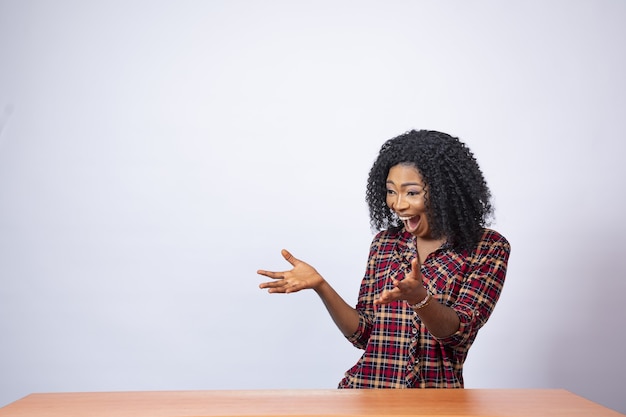 Foto grátis uma linda mulher gesticulando para o espaço ao seu lado com empolgação