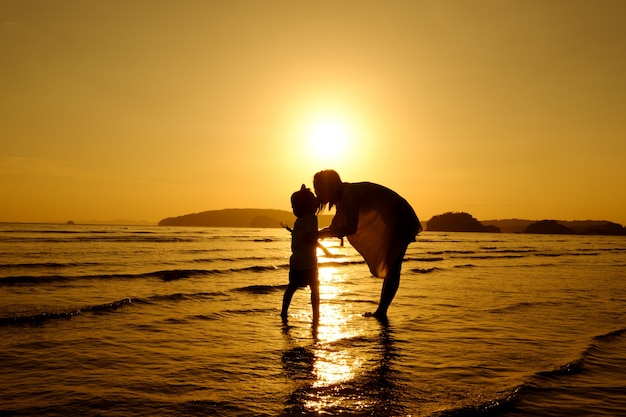 Uma mãe e filho ao ar livre ao pôr do sol com cópia espaço