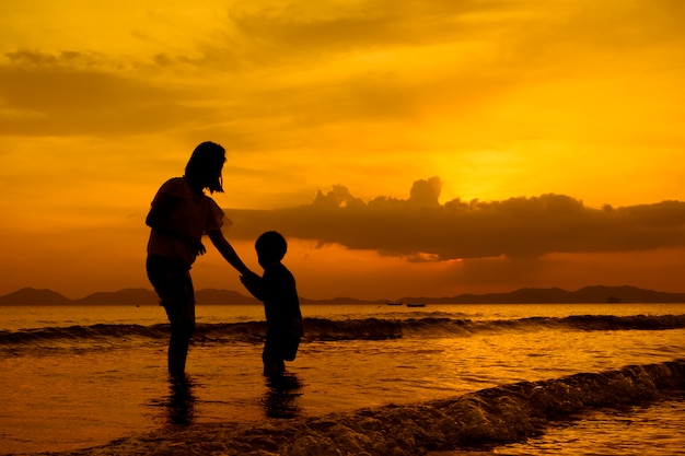 Uma mãe e filho ao ar livre ao pôr do sol com cópia espaço