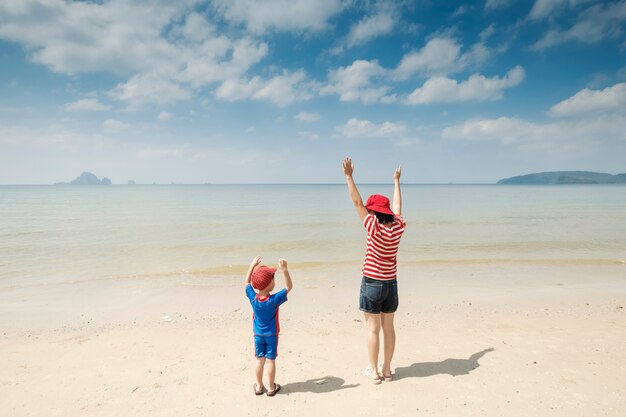 Uma mãe e filho na praia ao ar livre Mar e céu azul