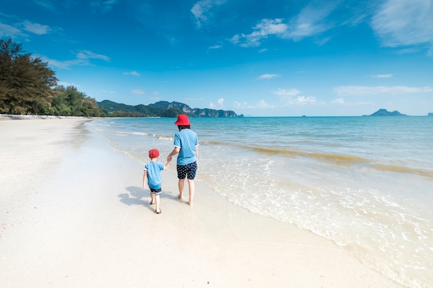 Uma mãe e filho na praia ao ar livre Mar e céu azul