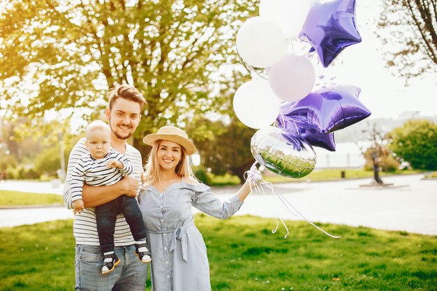 Uma mãe loira jovem e bonita em um vestido azul, junto com seu homem bonito