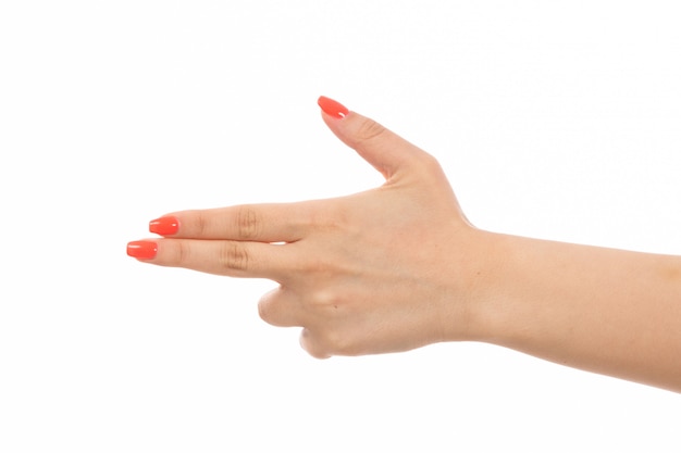 Uma mão feminina vista frontal com unhas coloridas, apontando a pose de arma no branco