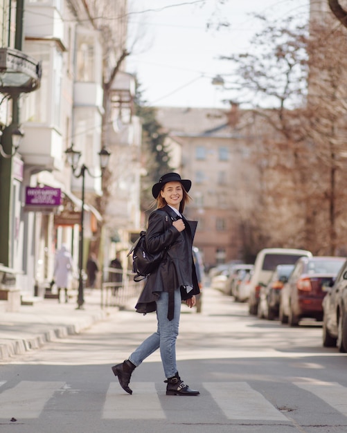 Foto grátis uma menina bonita anda pela cidade sorrindo e posando