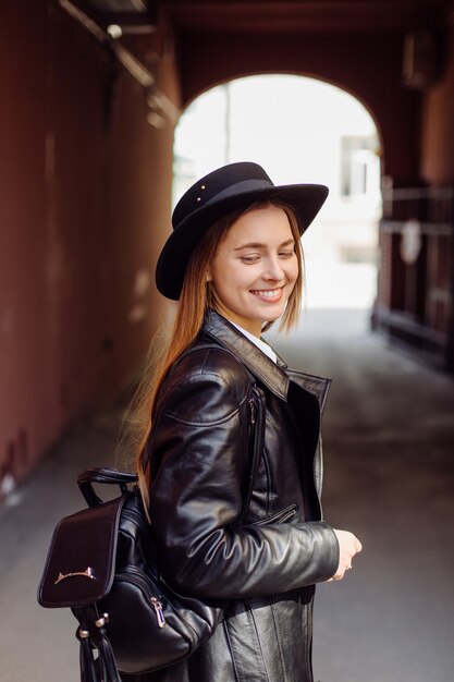 Uma menina bonita anda pela cidade sorrindo e posando