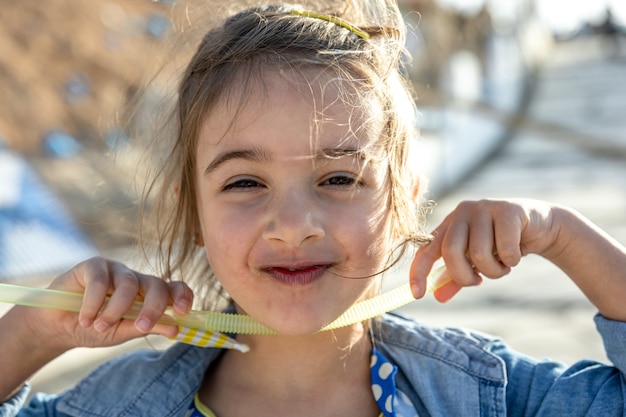 Uma menina bonitinha sorri e olha para a câmera.