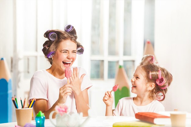 Uma menina sentada com a mãe tomando sorvete