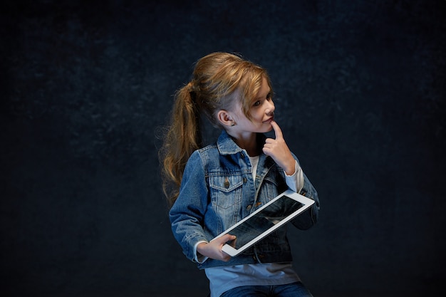 Uma menina sentada com tablet