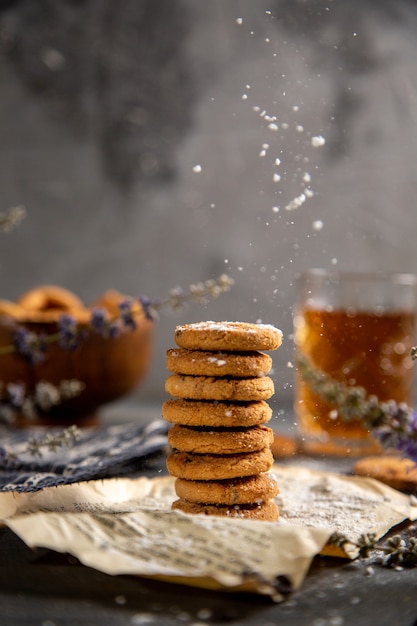 Uma mesa de frente com biscoitos e com chá na mesa cinza biscoito chá biscoito doce