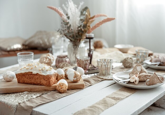 Uma mesa festiva com um belo cenário, detalhes decorativos, ovos e bolo de Páscoa.