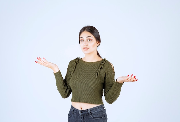 Foto grátis uma modelo de mulher chocada, olhando para a câmera e mostrando as mãos vazias.