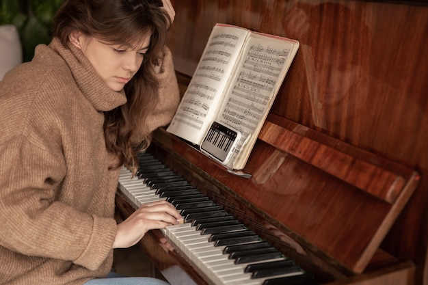 Uma mulher aprende a tocar piano usando um aplicativo em seu telefone