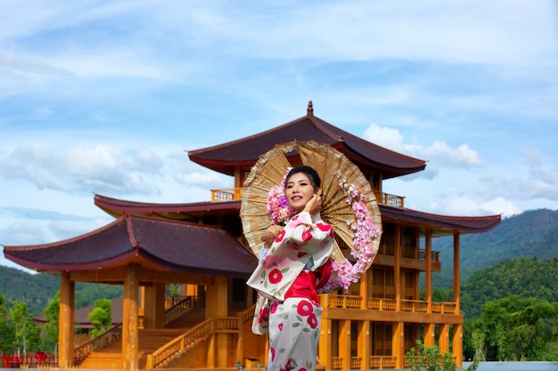 Uma mulher asiática bonita que desgasta um quimono japonês, conceito tradicional do vestido.