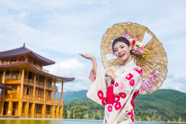 Uma mulher asiática bonita que desgasta um quimono japonês, conceito tradicional do vestido.