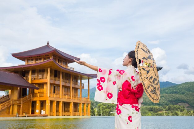 Uma mulher asiática bonita que desgasta um quimono japonês, conceito tradicional do vestido.