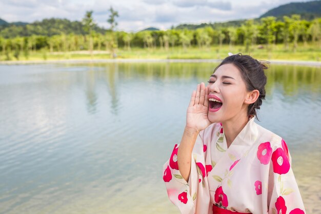 Uma mulher asiática bonita que desgasta um quimono japonês, conceito tradicional do vestido.