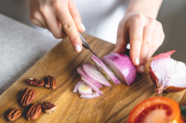 Foto grátis uma mulher corta legumes para um closeup de salada