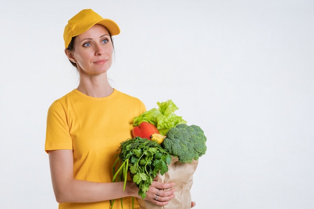 Uma mulher em roupas amarelas, entregando um pacote de comida, sobre um fundo branco